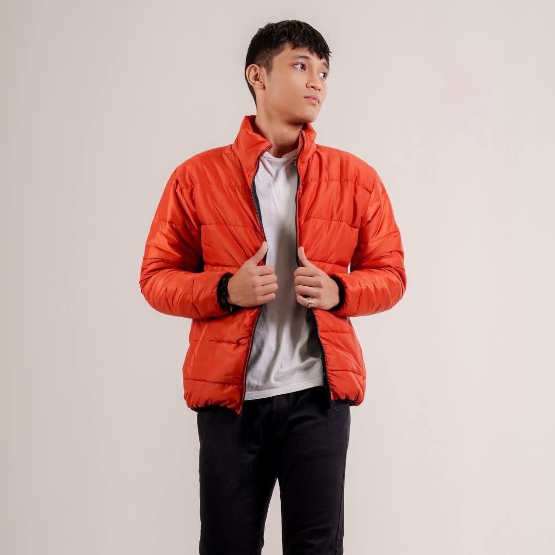 Burnt-orange quilted padded jacket, front view on model